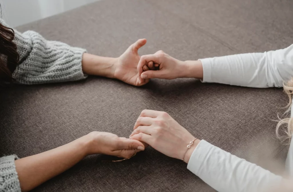 Women holding their hands together while praying